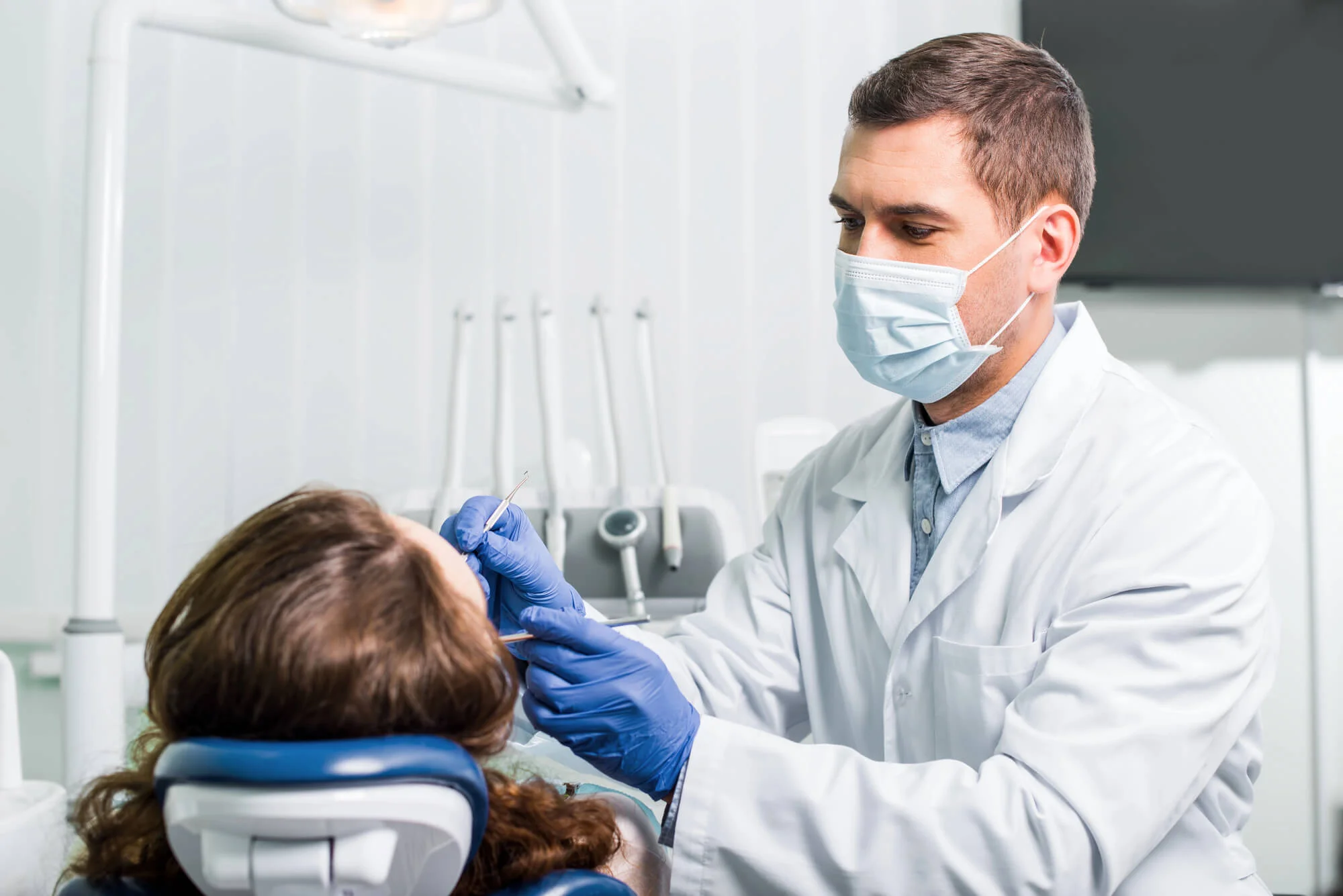 Dentist examining patient during checkup best dentist in Fort Pierce