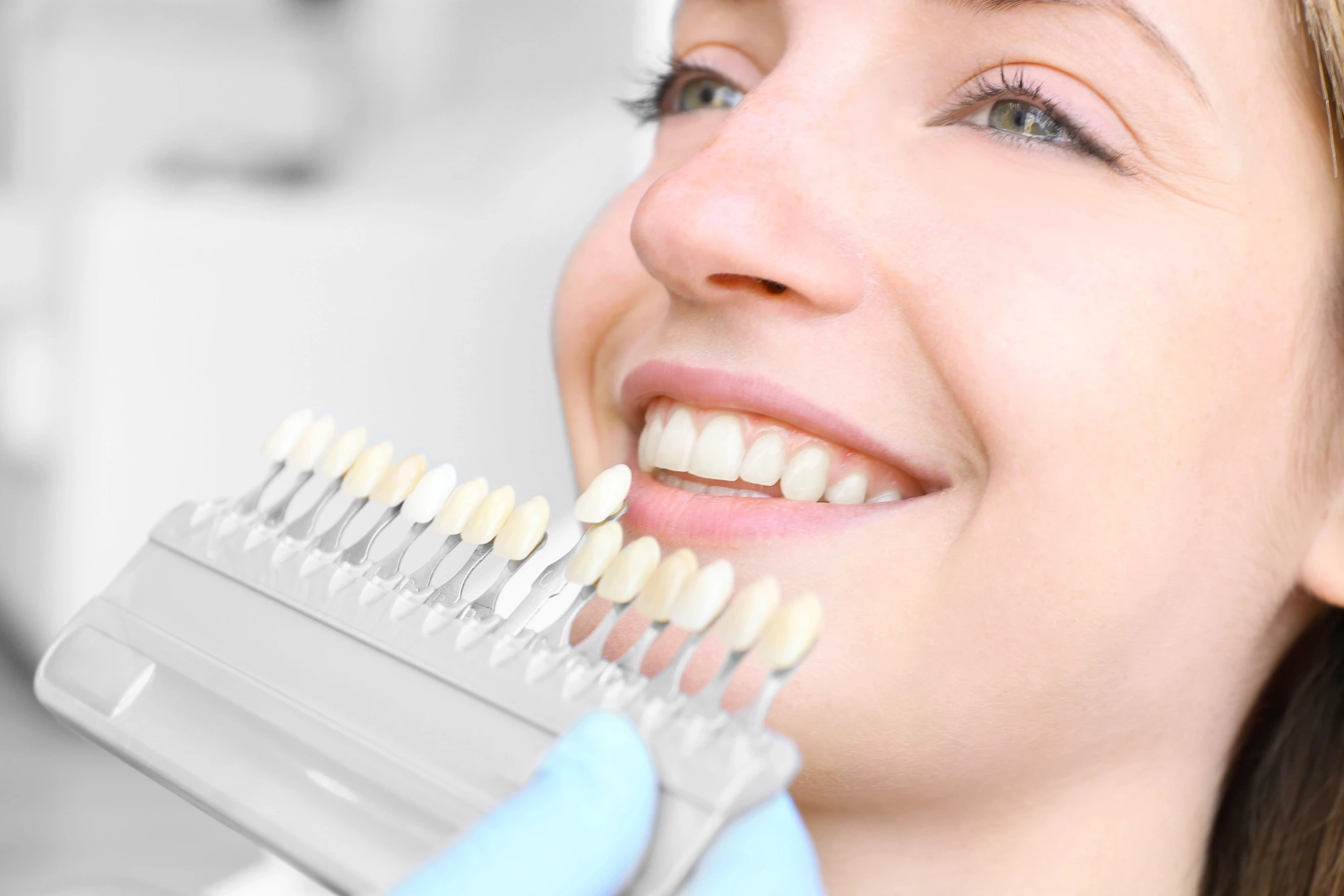 Woman comparing her teeth after teeth whitening by Dentist Fort Pierce